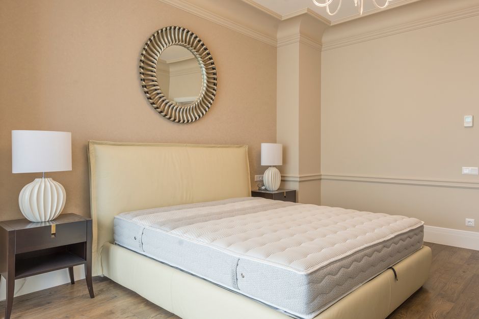 Spacious bedroom featuring modern decor, elegant lighting, and a plush bed with neutral tones. - Photo by Max Vakhtbovych on Pexels