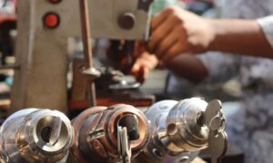 Close-up image of locksmith tools and hands working with a key machine outdoors. - Photo by Saad Bin Hasan on Pexels