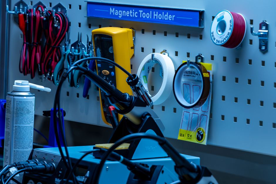 A neatly organized workbench featuring tools, cables, and a magnetic tool holder in a workshop. - Photo by Yudi Ding on Pexels